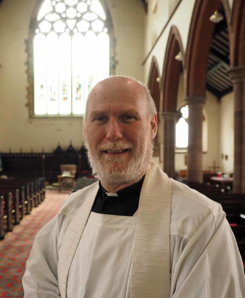 Photograph of Father Jack Knill-Jones inside St James' church.